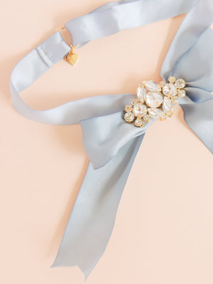 Mamie and James Amelie adjustable silk bow wedding garter in french blue with rhinestone appliqué in gold tone setting