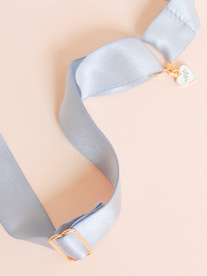 Mamie and James detail image of Amelie adjustable silk bow wedding garter in french blue with rhinestone appliqué in gold tone setting